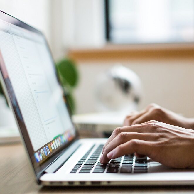 Person typing on Open Laptop